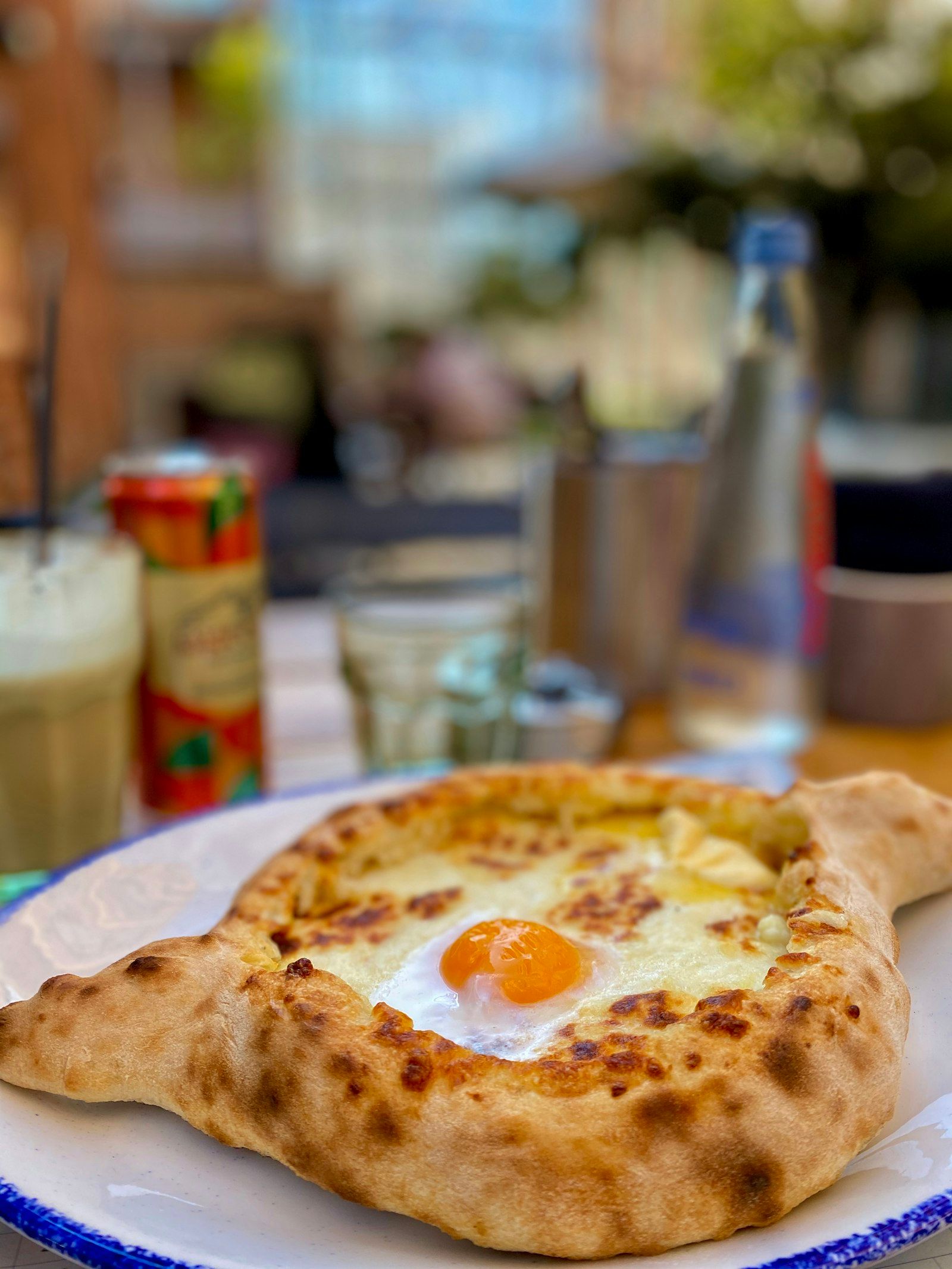 An adjarian khachapuri, the egg still soft, on a café table in Tbilisi
