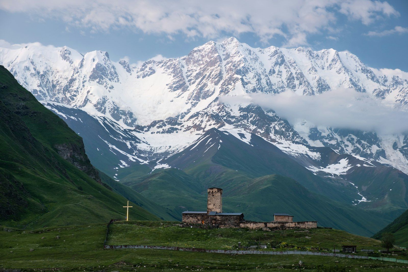 The Lamaria church at Ushguli beneath the snow wall of Mount Shkhara